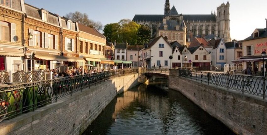 Amiens Glisy : Canal pittoresque avec café et église.