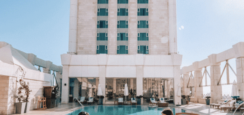 Chaises longues au bord de la piscine devant l'hôtel