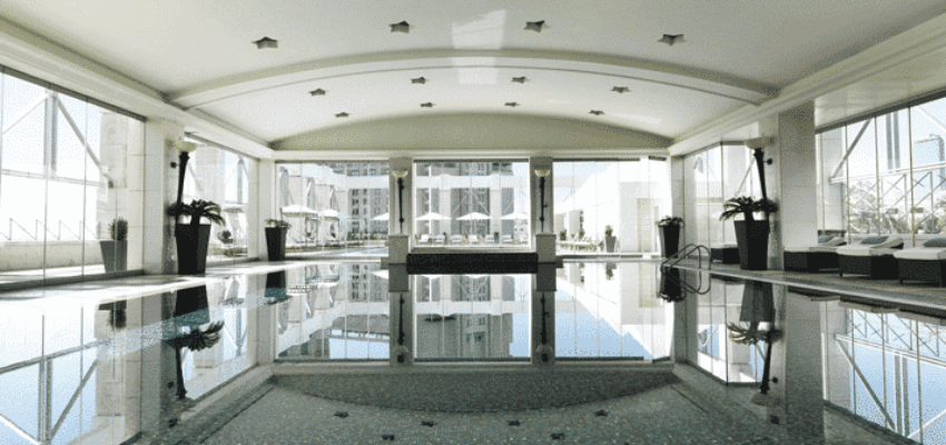Espace piscine intérieure avec fenêtres et plafond courbé