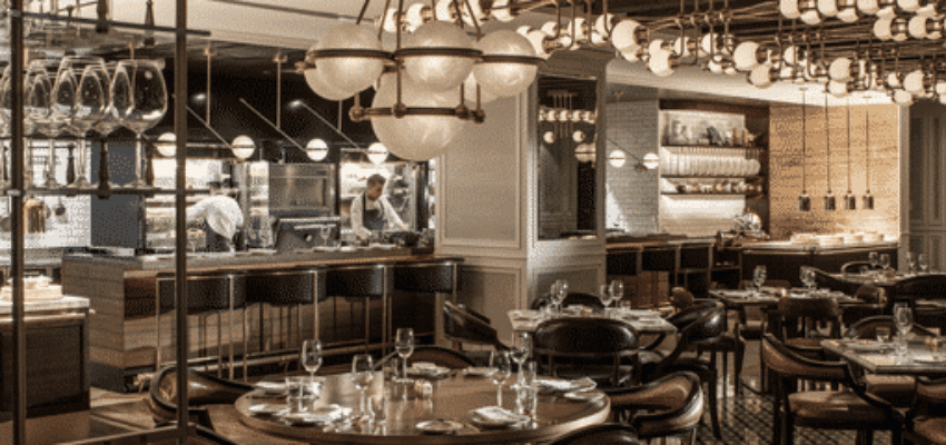 Restaurant élégant : intérieur moderne, tables dressées, cuisine ouverte.
