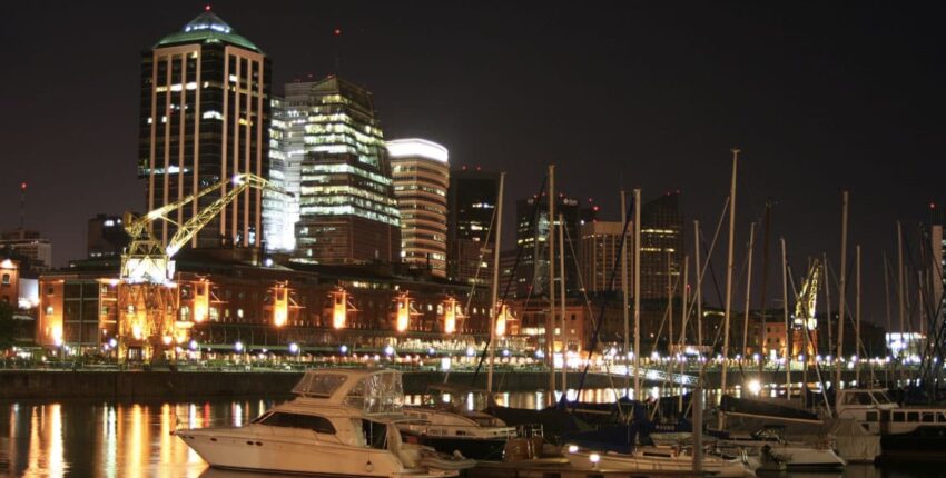 Cityscape nocturne – gratte-ciels illuminés et reflets sur l'eau.