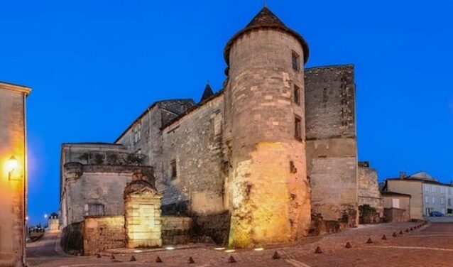 Cognac Châteaubernard fort et tour ronde illuminée au crépuscule.