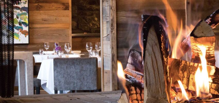 Restaurant élégant avec cheminée en brique et tables dressées.