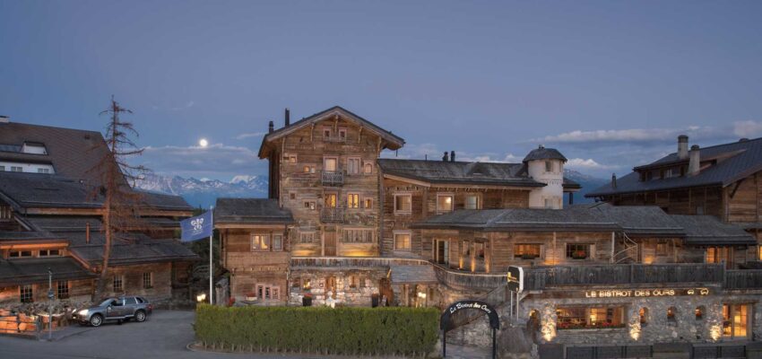 Montagne - Chalets rustiques éclairés au crépuscule.