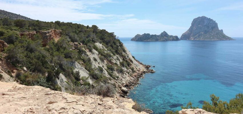 Vue sur mer depuis la falaise avec îles rocheuses lointaines.