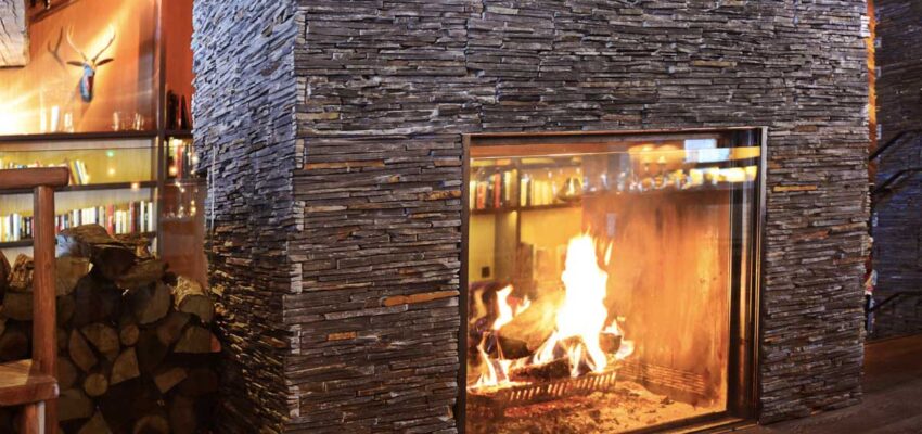 Cheminée en pierre avec feu de bois chaleureux.
