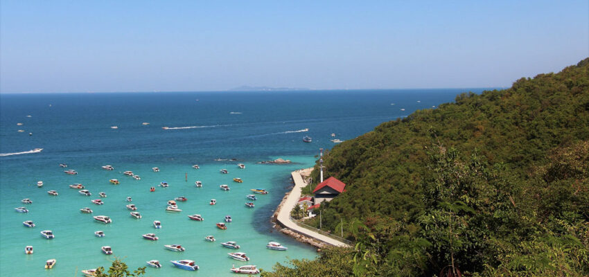 Littoral turquoise, bateaux, verdure luxuriante aux alentours.