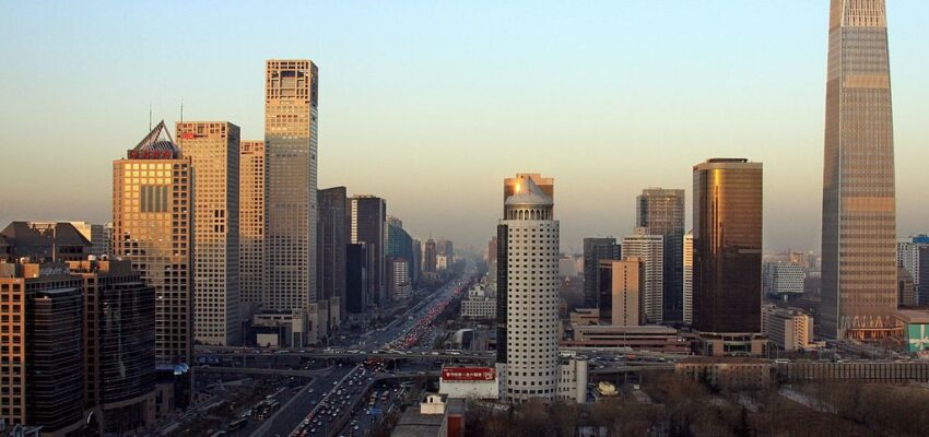 Coucher de soleil sur un paysage urbain : hauts gratte-ciels, autoroute très fréquentée.