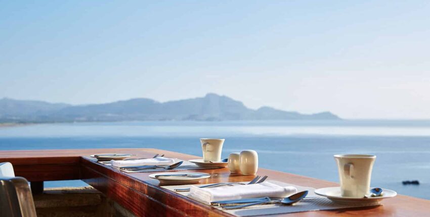 table à manger au bord de l'océan avec vue sur la montagne