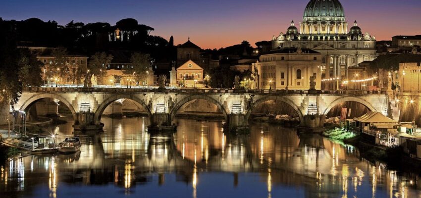 Vacance en Europe : pont illuminé, ciel crépusculaire, rivière.