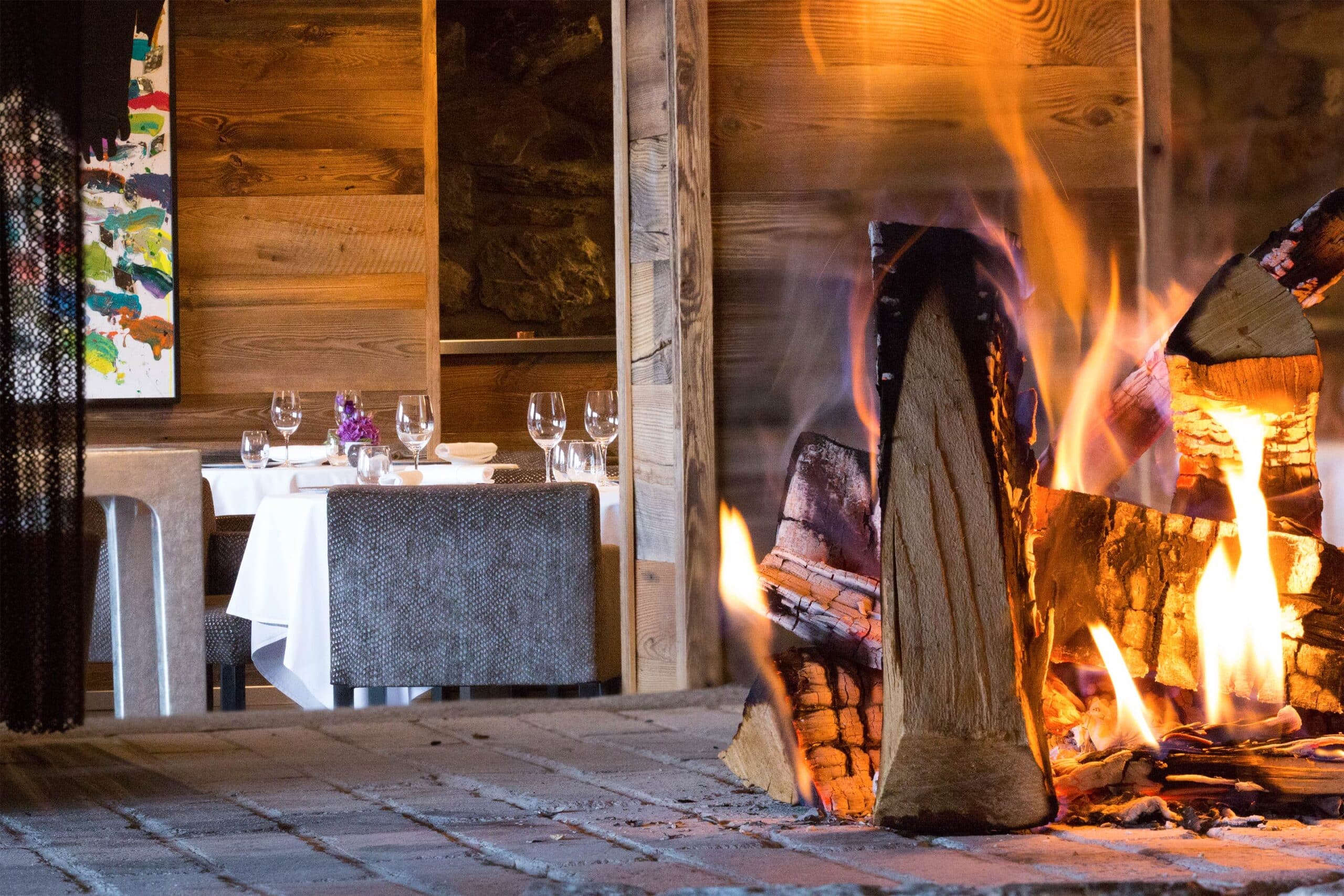**Alternative Balise :** Restaurant cosy Crans Montana, cheminée bois tables dressées
