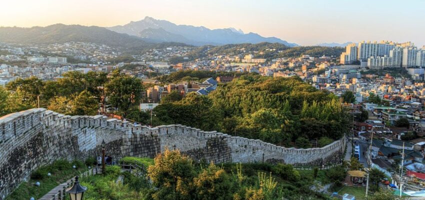 Vue panoramique sur la ville, mur historique avec montagnes.