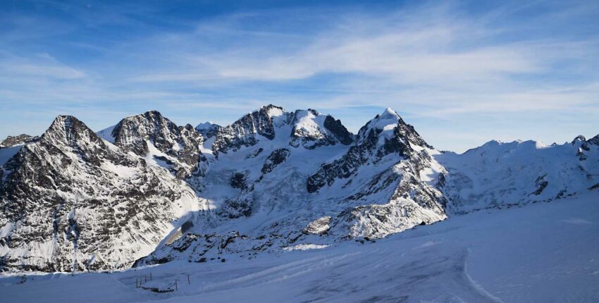 Saint-Moritz - Samedan, montagnes enneigées, ciel bleu clair.