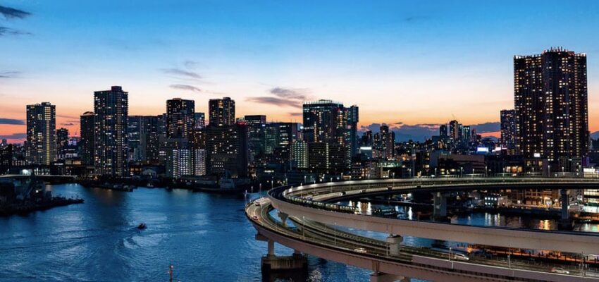 Skyline ville crépuscule, route courbe sur rivière.