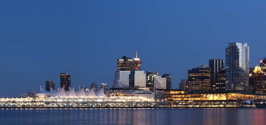 Skyline nocturne avec bâtiments éclairés, structures en voile.