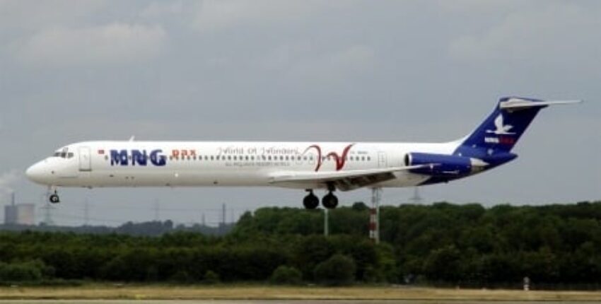 Location de jet privé : Avion MD 82 atterrissant devant arbres.