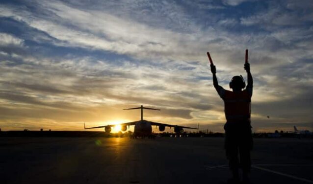 Location jet privé : équipage d'AEROAFFAIRES guidant l'avion au coucher du soleil.