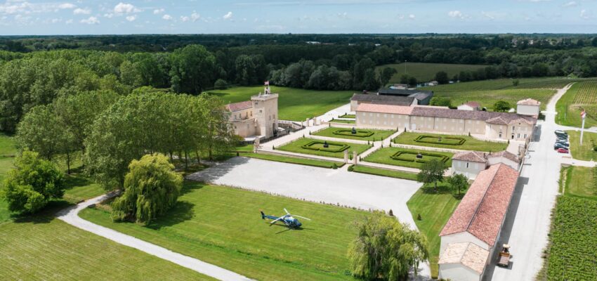 Château et jardins avec hélicoptère sur la pelouse.