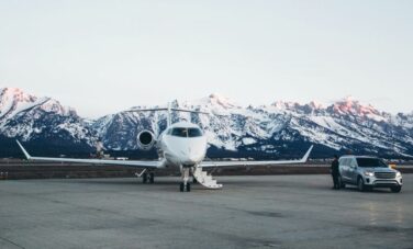 Un jet privé et une voiture du luxe au milieu des montagnes