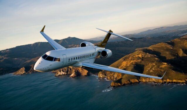 Le jet privé Bombardier Global 6000 en vol avec un couché de soleil, la mer et des montages