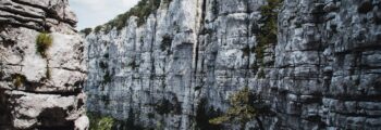 Alghero Fertilia : falaises, végétation, mer bleue.