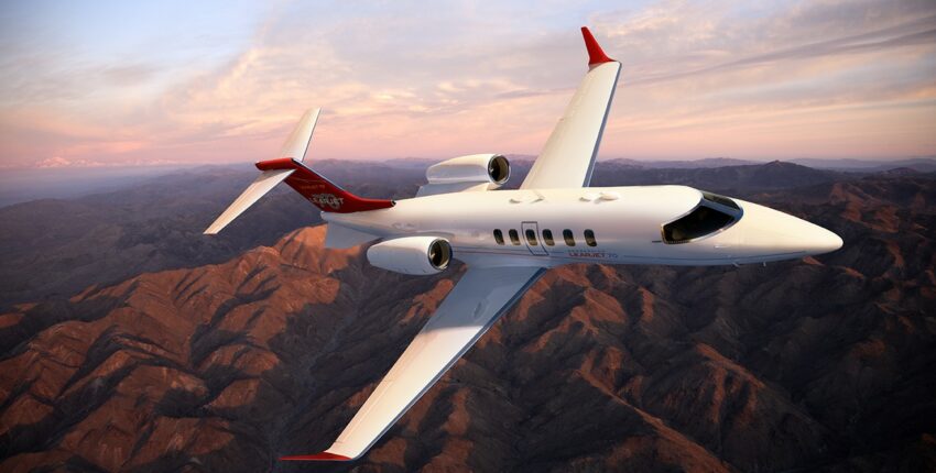 location de jet privé: LEARJET 70 survolant montagnes au coucher du soleil